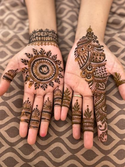 A beautiful combination of styles. One hand features a simple mandala with a lotus inside, while the other has a more intricate paisley design, showing how you can mix and match.