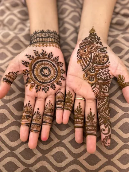 A beautiful combination of styles. One hand features a simple mandala with a lotus inside, while the other has a more intricate paisley design, showing how you can mix and match.