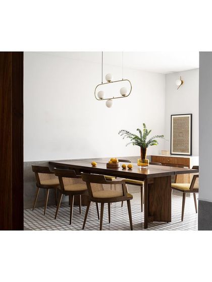 Another angle of the dining space, highlighting the elegant chairs and the long wooden table.