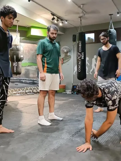 I am constantly observing and correcting form. Here, I am teaching a student the mechanics of a ground and pound escape, a crucial skill for getting back to your feet in a fight.