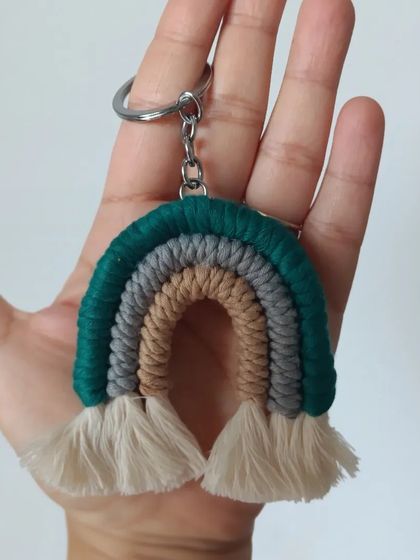 A rainbow keychain in earthy tones of green, grey, and beige.