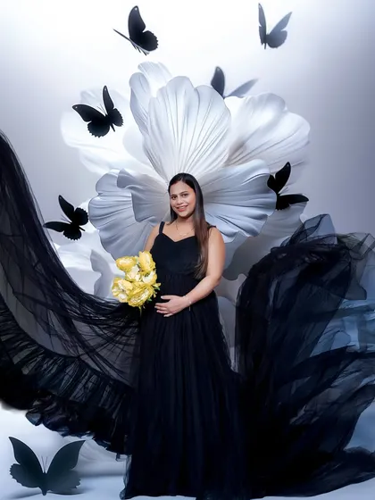 For a more whimsical feel, we added these butterfly props to the floral backdrop. It adds a layer of storytelling to this beautiful black and white themed maternity portrait.
