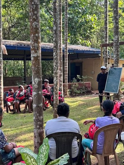 An instructor uses a whiteboard to explain the principles of water safety before a kayaking session at our Dandeli camp. We combine practical skills with essential theory.
