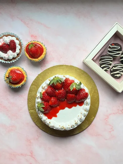 Another view of our strawberry season spread, featuring our strawberries and cream cake, mini tarts, and a box of chocolate-dipped strawberries.