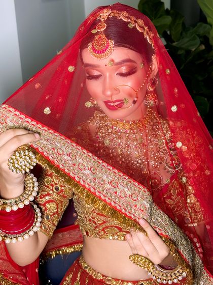 A beautiful shot of a bride with her red dupatta, showcasing her elegant makeup and the rich color of her outfit.