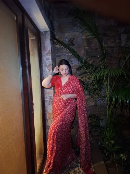 A quiet moment. The rich red of the saree and the intricate print make it a statement piece on its own.