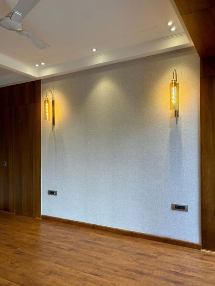 The textured wallpaper and modern wall sconces are the first layers of design in this room, setting a sophisticated tone for the space.