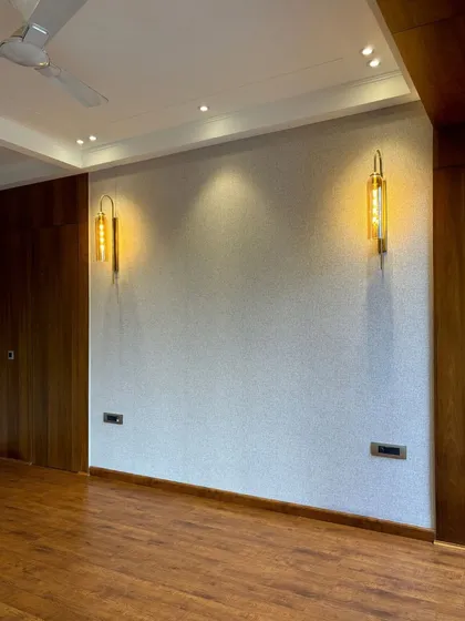 A detail of the accent wall in the unfurnished bedroom, featuring elegant wall sconces that add a touch of warmth and sophistication.