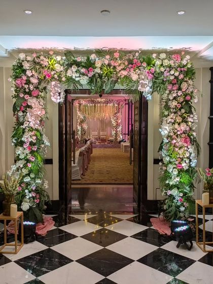 A floral entrance is a beautiful way to welcome guests. For Mehek and Rishav's wedding, I crafted this dense arch of pink and white flowers over a checkered marble floor, creating a stunning contrast.