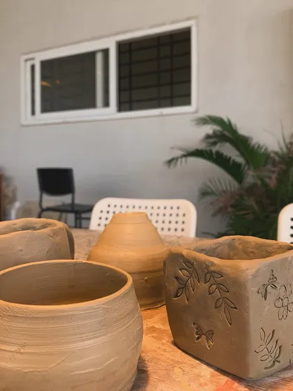 A collection of raw clay pieces on a table, showing the different shapes and textures possible with hand-building.