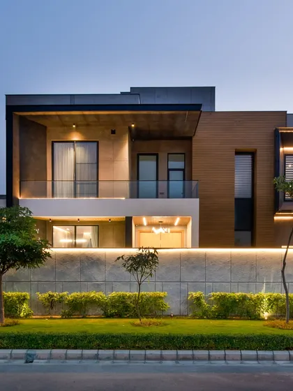 A frontal view of the Sonipat home at dusk, showing the balance between the illuminated interior and the softly lit exterior.