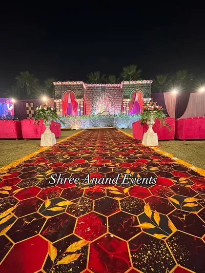 A perfectly symmetrical view down a grand aisle, leading to a beautifully decorated stage, showcasing the scale of our outdoor setups.