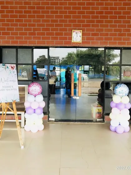 The entrance to a baby shower venue, with a welcome easel and balloon pillars.
