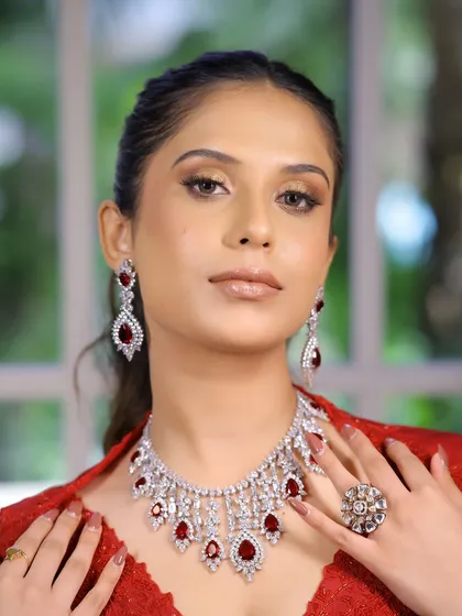 This is a powerful, monotone makeup look perfect for a sangeet or cocktail event. I paired soft, bronzy shimmer on the lids with glossy nude lips to let the stunning red outfit and ruby jewellery shine.