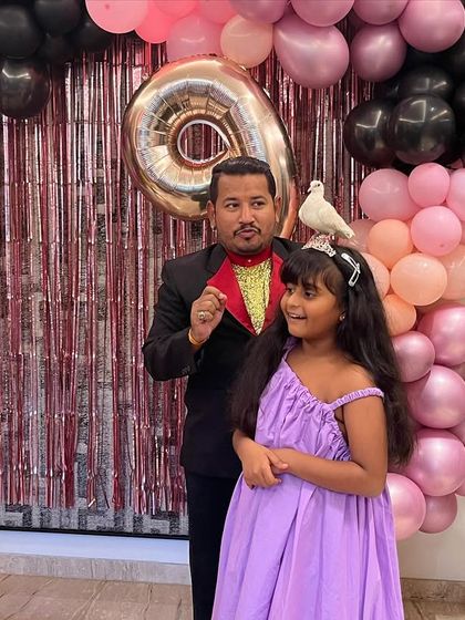 The grand finale of a trick. A beautiful white dove has just appeared and is resting on the birthday girl's head. It's a gentle, amazing moment that she and her friends will never forget.