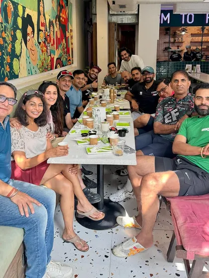 A table full of happy cyclists enjoying breakfast together.