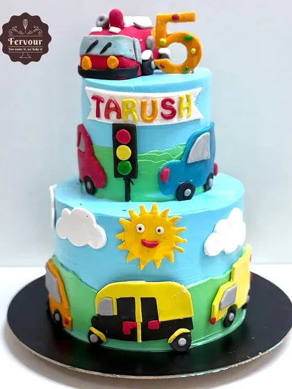 A transport theme cake for a 5th birthday. This three-tier cake is decorated with various vehicles like a bus, auto-rickshaw, and cars.