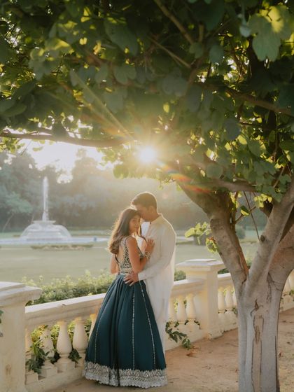An intimate embrace under a tree as the sun sets over the palace gardens. The lens flare adds a dreamy, romantic quality to this beautiful pre-wedding portrait.