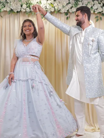 The bride twirls in her beautiful pastel blue lehenga. The makeup is designed to be photogenic from every angle, with a subtle glow that catches the light as she moves.