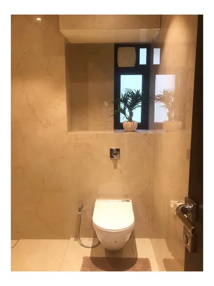 A minimalist master bathroom transformation. We used large-format marble-look tiles for the walls and a simple floating toilet to create a clean, spacious, and serene feeling.