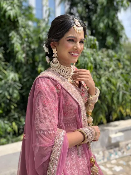 The complete look, with a beautiful hair updo adorned with flowers, perfectly complements her traditional attire.