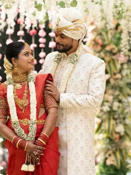 A classic portrait of a couple during their South Indian wedding, set against a beautiful floral curtain backdrop.