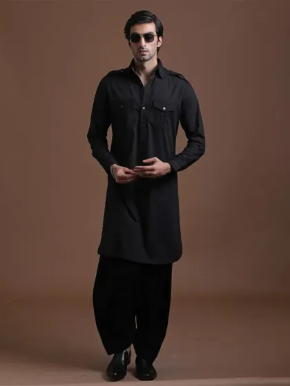 The quintessential black Pathani suit. With its structured shoulders and traditional silhouette, this is a powerful and classic look, perfect for making a confident statement at any cultural event.