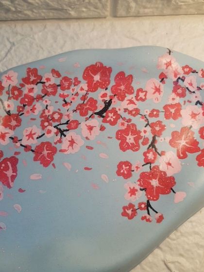 A close-up of the hand-painted cherry blossom design on our oval cloud tray.