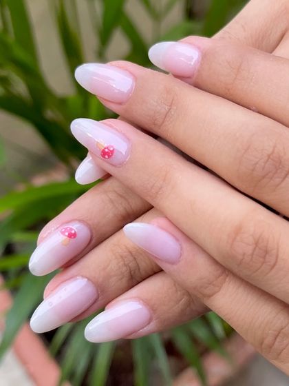 A full view of the whimsical mushroom dip powder nails. The soft, milky ombré base provides the perfect canvas for the tiny, hand-painted details.