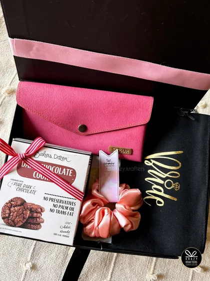 I can create beautiful bride hampers to fit any budget. This one includes a personalized 'Bride' pouch, a pink wallet, cookies, and a scrunchie, all in a chic black box.