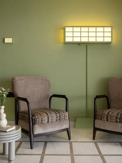 A pop of apple green on the wall marks the arrival at our 'Gingham Dreams' project. The sitting area features a duo of armchairs and a unique light-box style floor lamp that we had fixed to the wall per our client's request.