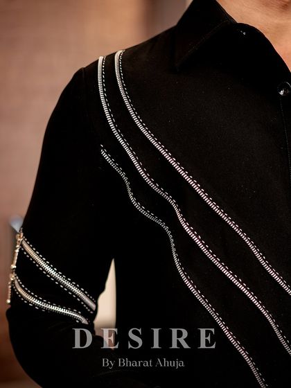 A detailed shot of the silver zipper and embroidery work on a custom black shirt. I use these elements to create dynamic, diagonal lines that are both edgy and elegant.