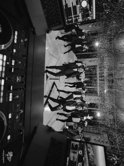 An aerial black and white shot of the groomsmen's dance performance at the reception. This unique perspective captures the choreography and energy of their tribute to the groom.