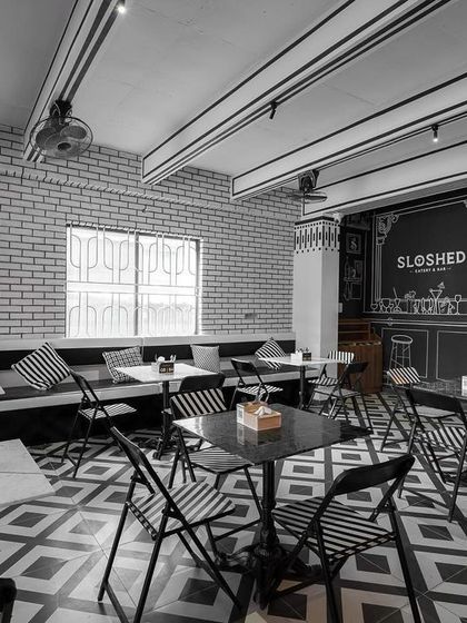 The seating area of the sketch cafe, where even the chairs and tables are part of the monochromatic theme. The design consistency creates a powerful and immersive atmosphere.