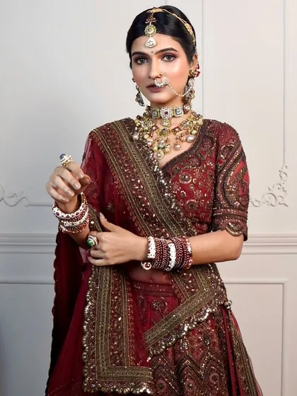 A full portrait showing the complete regal look. The makeup is designed to be bold enough to match the grandeur of the lehenga and jewellery.