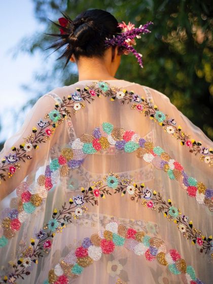 Another stunning detail shot of the colorful, textured embroidery on the sheer cape. It’s a piece of wearable art, captured beautifully against the light.