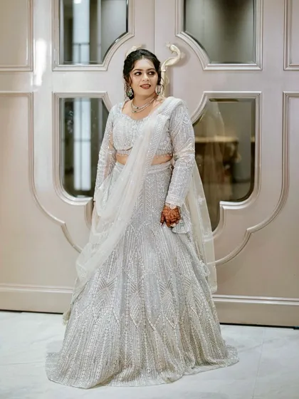 A full view of this bride's stunning silver lehenga. The soft glam makeup and elegant updo complete the sophisticated look.