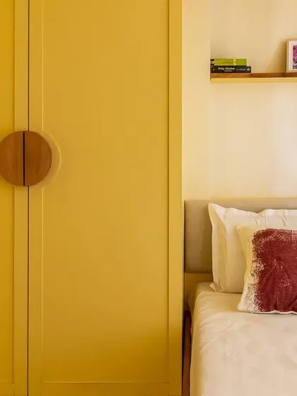 Another angle of the cozy bed nook, with a simple floating shelf for personal items, making the most of the limited space.