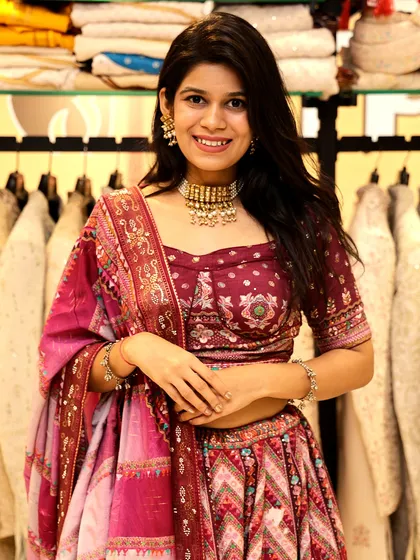 A close-up of the maroon printed lehenga, highlighting the intricate patterns and rich colors.