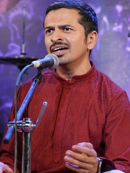 Guru Bhargav Sir sings alongside his student, demonstrating a passage during the Bhadrachala Ramadasa Kriti performance.
