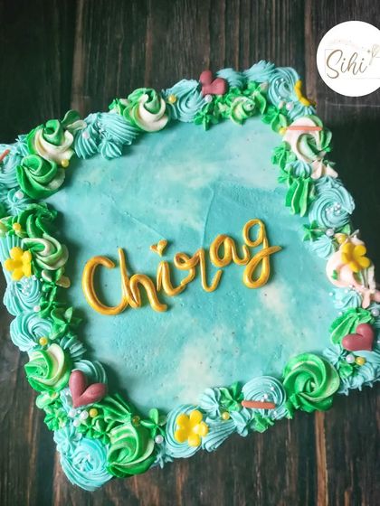 Square cakes aren't my favorite to work on, but I'm always happy to improve my skills. This one features a lovely aqua-blue watercolor effect and a border of green piped florals.