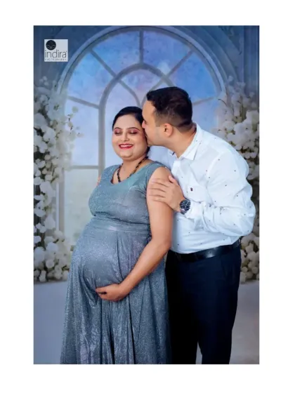 A sweet and tender moment as the father-to-be kisses his partner's cheek during their studio maternity session.