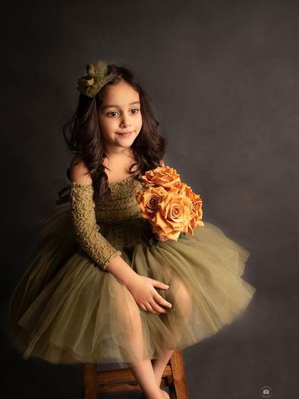 A candid side profile, capturing a gentle smile. The soft lighting beautifully highlights her features against the dark backdrop.