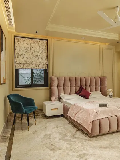 This bedroom uses a chic, modern approach with color blocking as a key feature. The blush pink channel-tufted bed contrasts beautifully with the teal accent chair, creating a youthful and fun vibe.
