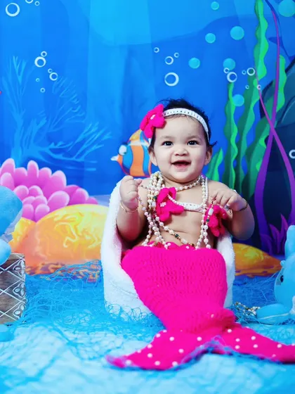 A happy little mermaid poses for her portrait in our under-the-sea studio.