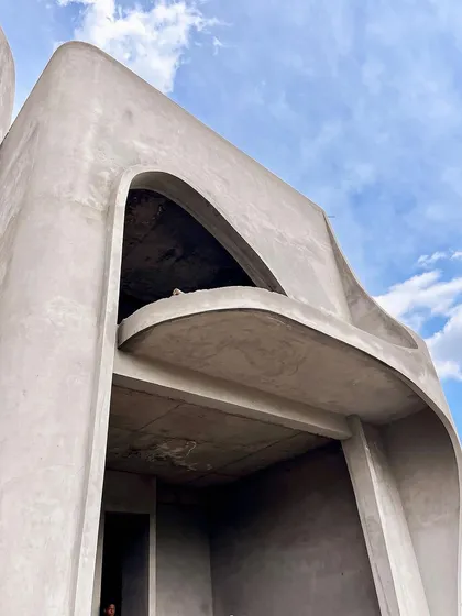 A detail of one of the curved balconies, which emerge like breaths of wind, harmonizing with the overall structure.