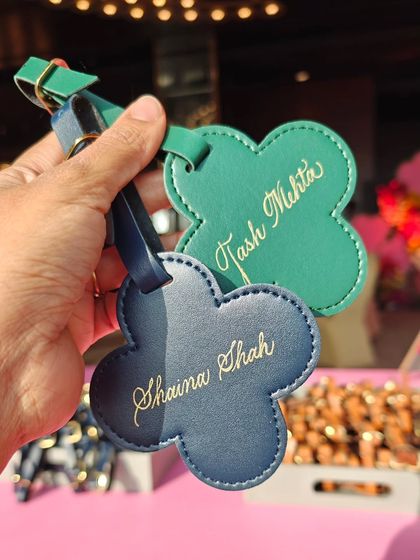 Live personalization on luggage tags at a Mehendi function. The floral shape of the tags complemented the event's decor perfectly.