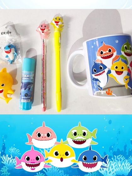 Here are the contents of the Baby Shark hamper: a mug, themed pens, a 3D eraser, a glue stick, and a sharpener.