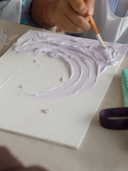 A close-up of a participant creating a wave effect with texture paste. This is the first step to creating a stunning 3D artwork.