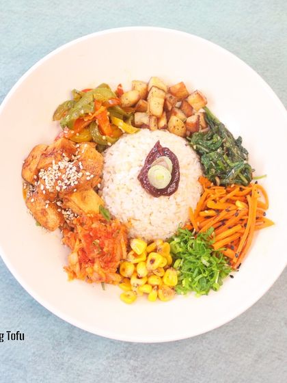 Korean Mixed Rice Bowl: Gochujang Tofu Bibimbap: Bibimbap means "mixed rice" and is a Korean staple. Our vibrant bowl features spicy gochujang tofu, an array of fresh and pickled vegetables, and a perfectly cooked mound of rice.
